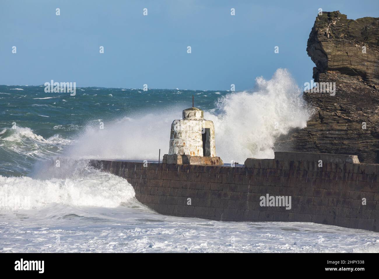 Portreath, Cornovaglia, 24th febbraio 2022, forti venti di 46mph con le docce di grandine ha causato grandi onde a Portreath, Cornovaglia questa mattina. La temperatura era di 7C ma con il fattore windchill si sentiva come 2C. Gli escursionisti di cani e le persone hanno ancora coraggiato una passeggiata lungo la spiaggia.Credit: Keith Larby/Alamy Live News Foto Stock