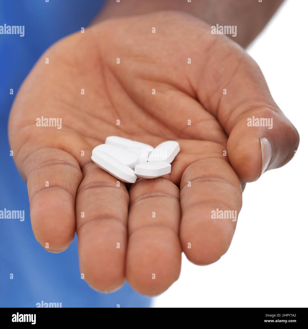 Dipendente dal medico. Vista ritagliata di una mano di mans che tiene fuori alcune pillole bianche. Foto Stock