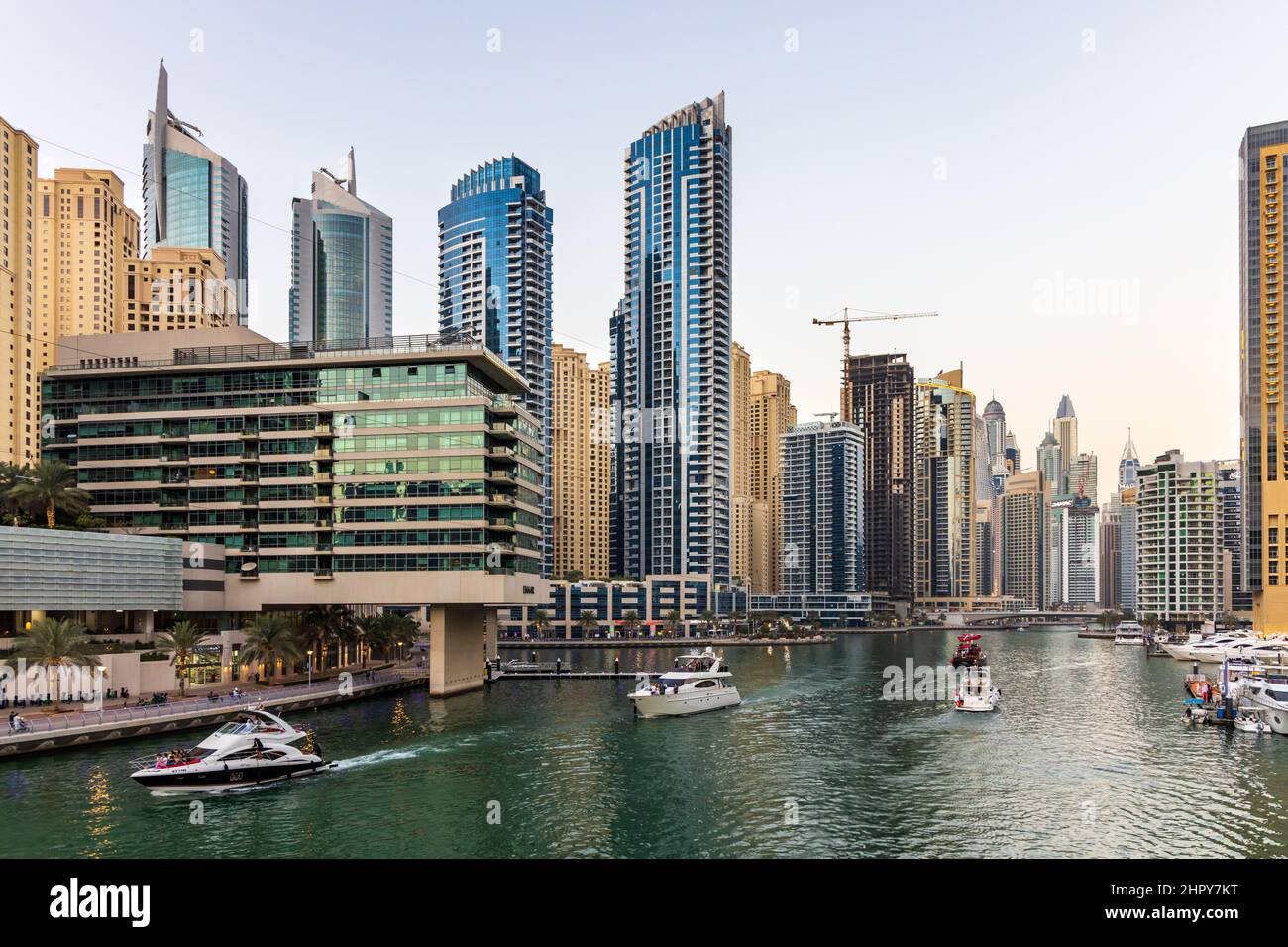 Barche e barche in crociera a Dubai Marina, circondato da numerosi grattacieli residenziali, ristoranti, negozi e alberghi. EMIRATI ARABI UNITI Foto Stock