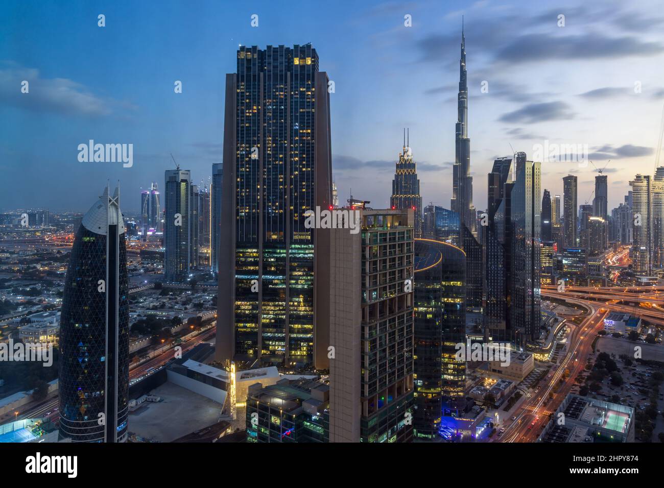Vista aerea al tramonto del centro di Dubai, con grattacieli e il Burj Khalifa in lontananza. Foto Stock