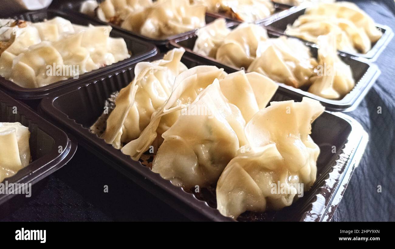 Molti spuntini giapponesi di Street food gyoza su vassoio di plastica scuro per un piccolo menu di affari del ristorante Foto Stock