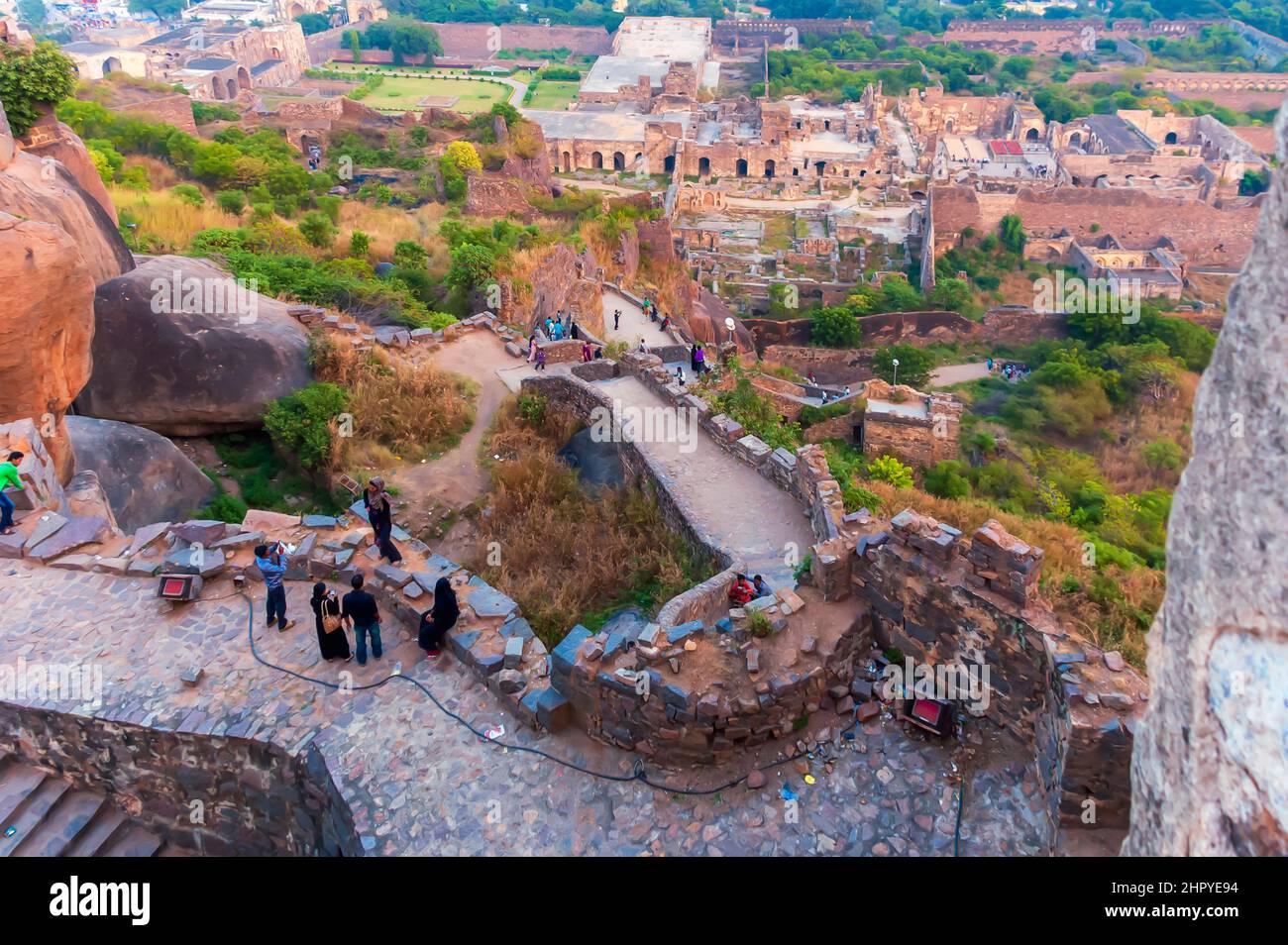 Una vista delle rovine del forte Golconda dalla cima della cittadella fortificata. Pareti di granito intemperie sono visibili. I turisti sono visti posare per le immagini. Foto Stock