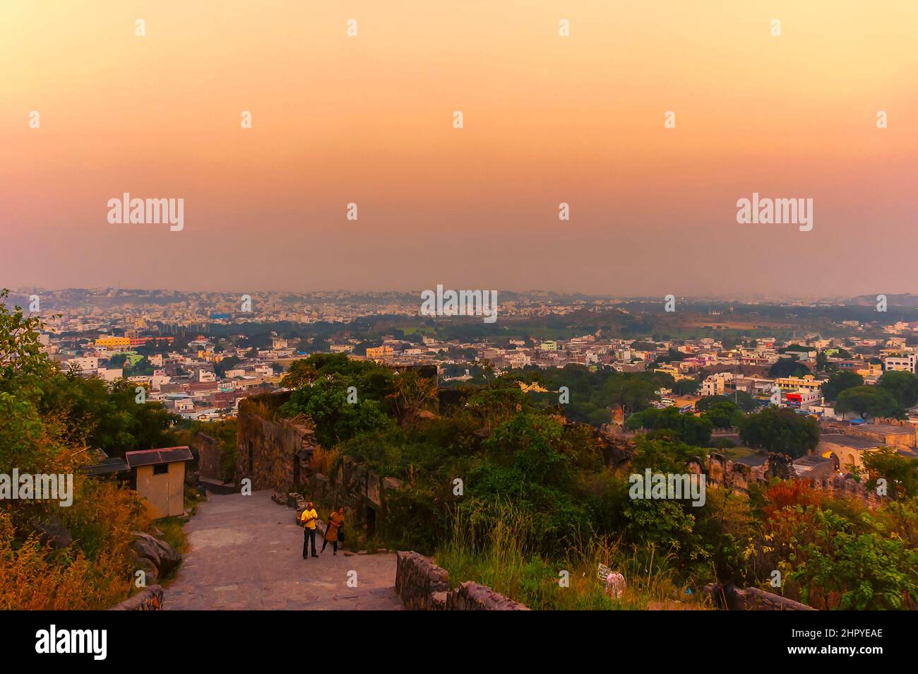 Una vista di Hyderabad, India, dalla cima del forte di Golconda. Il sole che tramonta irradia un bagliore giallo-arancio sui cieli sopra la città delle perle. Foto Stock