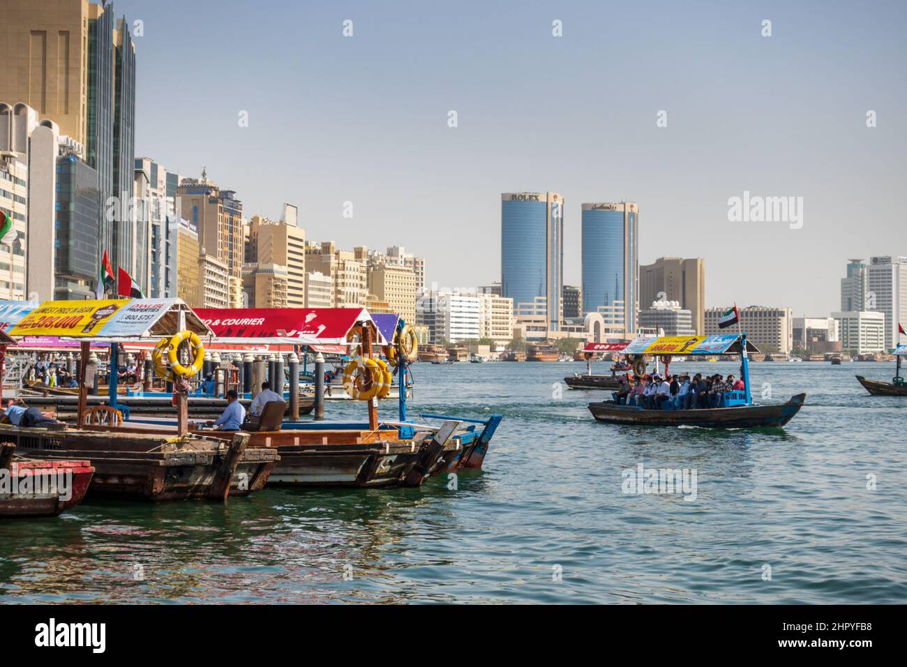 I turisti attraversano il Dubai Creek in una tradizionale barca abra nella città di Dubai, Emirati Arabi Uniti. Foto Stock