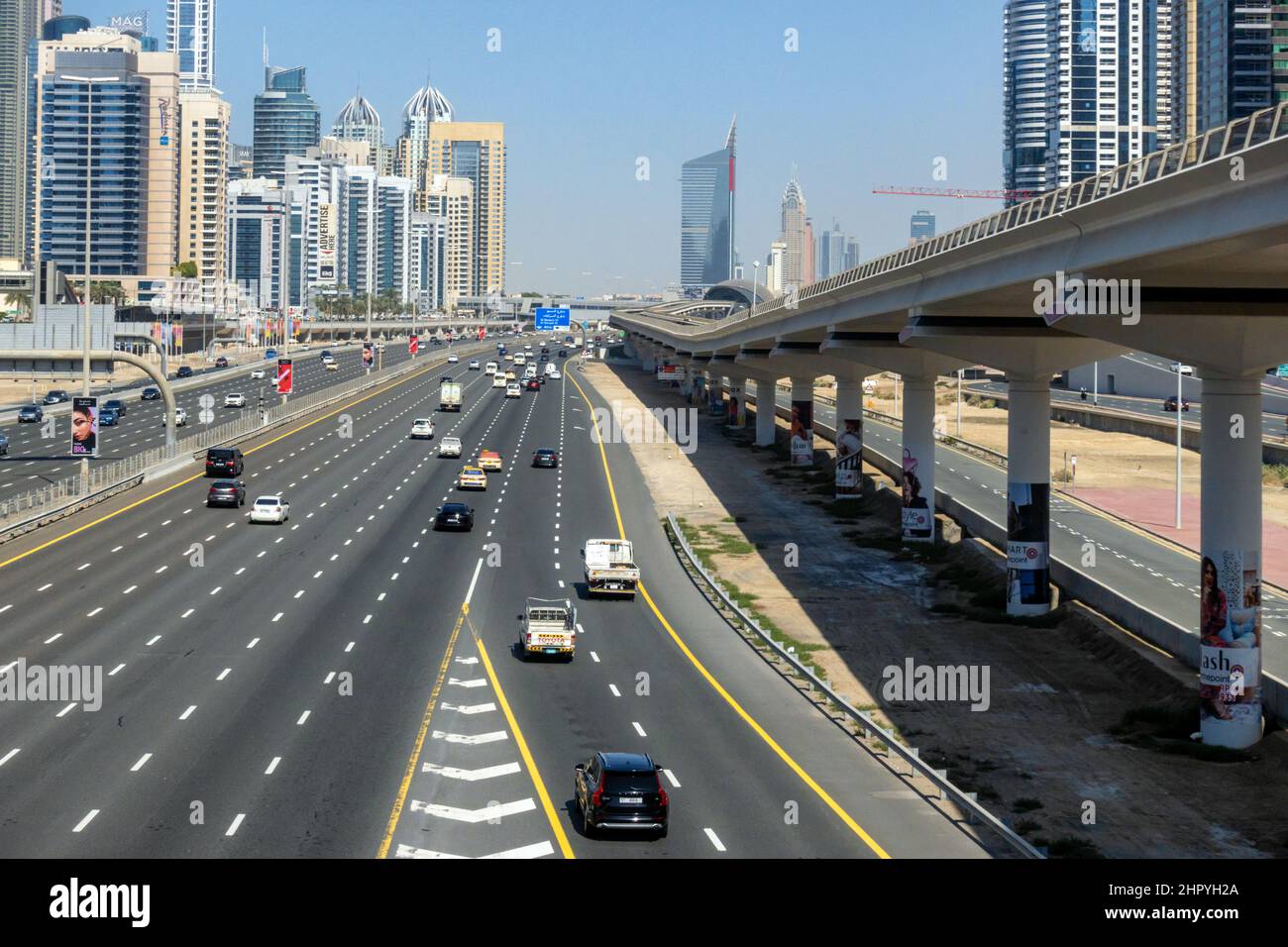 Sheikh Zayed Road, con la linea della metropolitana che costeggia la città di Dubai, Emirati Arabi Uniti. Foto Stock