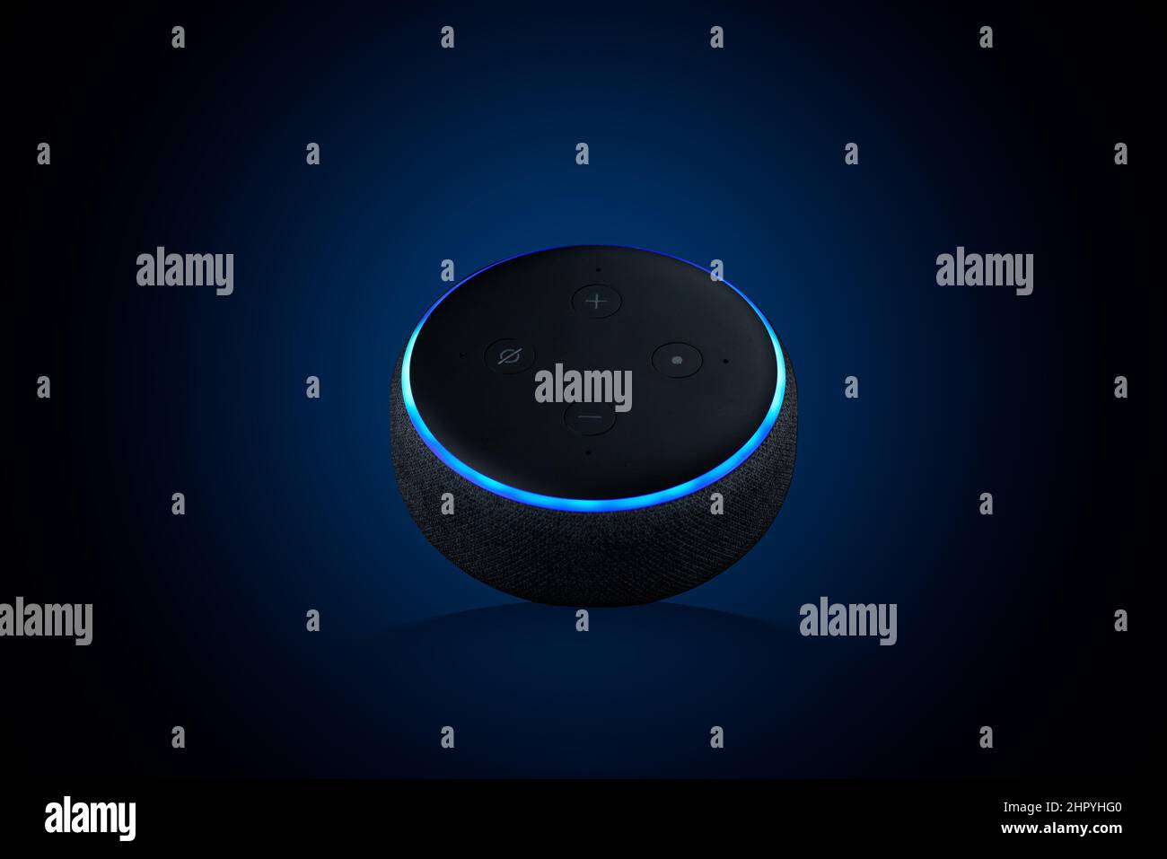 Primo piano di un punto Echo, assistente vocale su sfondo blu scuro Foto Stock
