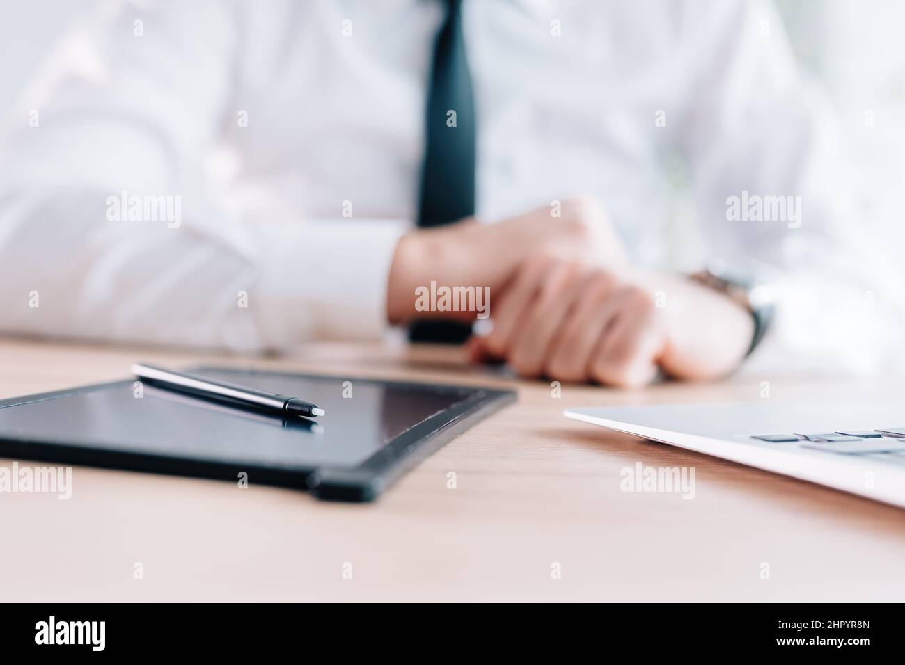 Stilo e pad e-Signature sulla scrivania dell'ufficio, mani di un uomo d'affari in background, fuoco selettivo Foto Stock