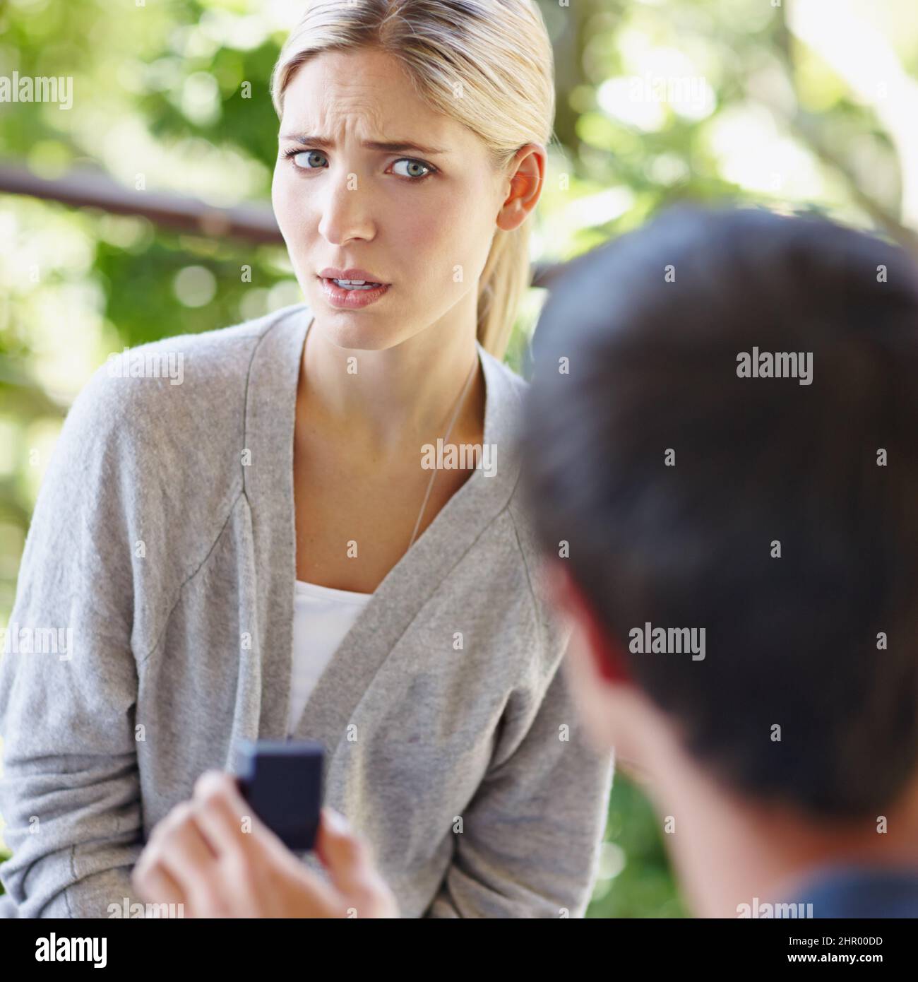 Mi stai scherzando. Scatto di una bella giovane donna che guarda incerto come il suo ragazzo sta proponendo. Foto Stock