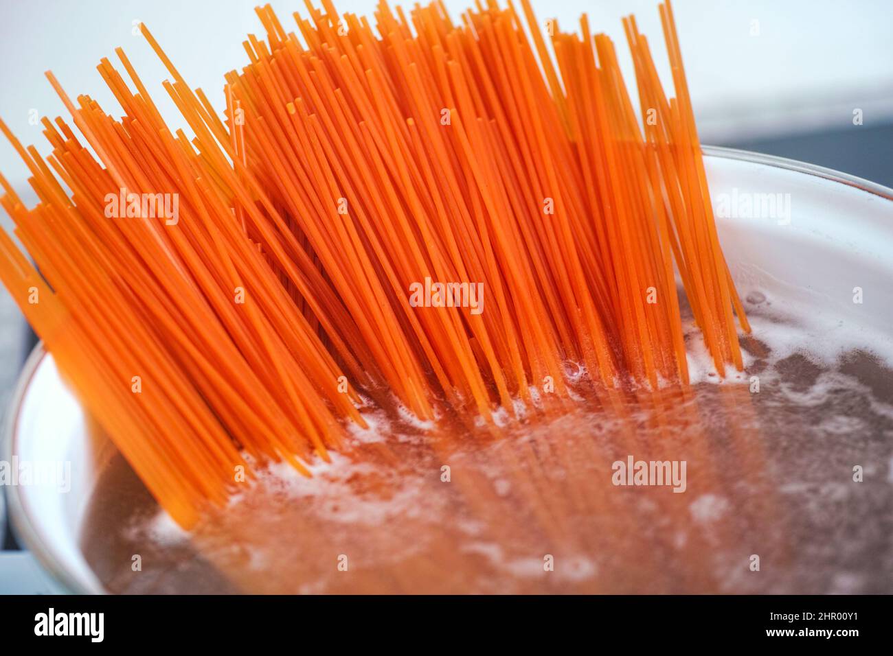 Pasta di lenticchie rosse senza glutine bollente in una pentola. Primo piano. Foto Stock