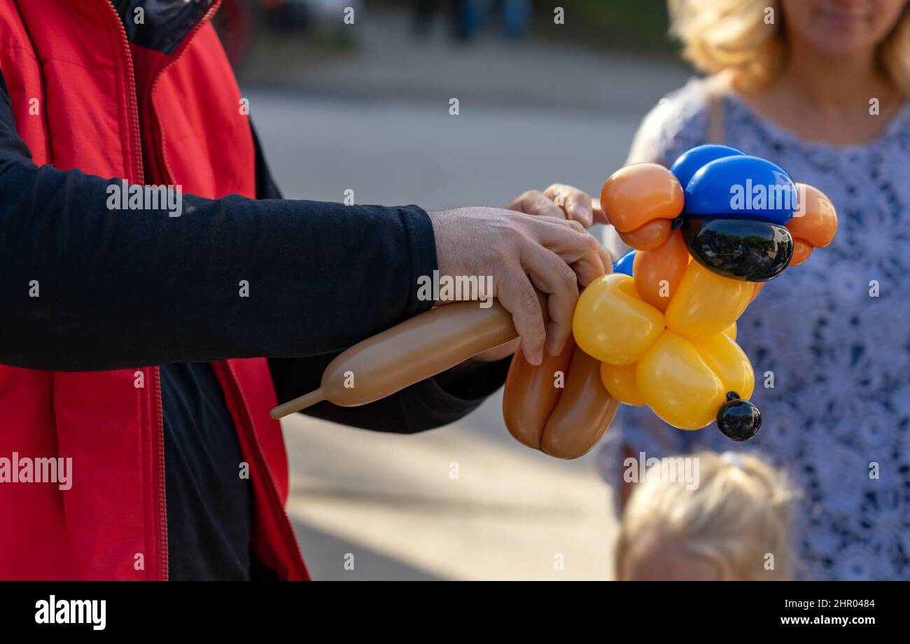 uomo che fa divertente balloon cane figura per i bambini Foto Stock
