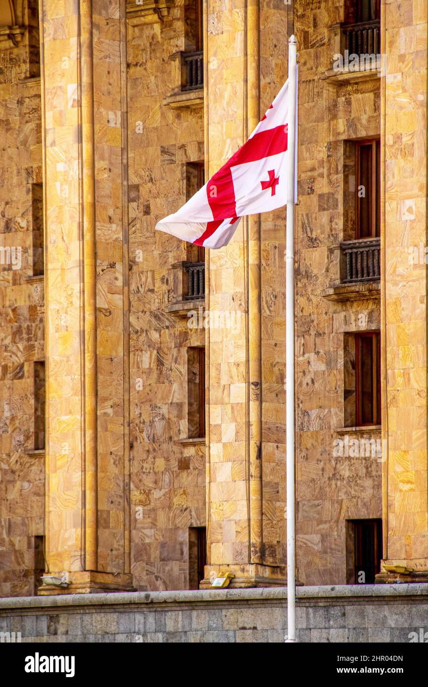 Edificio del Parlamento in marmo georgiano a Tbilisi Georgia con bandiera georgiana su un'alta asta di bandiera - Closeup. Foto Stock
