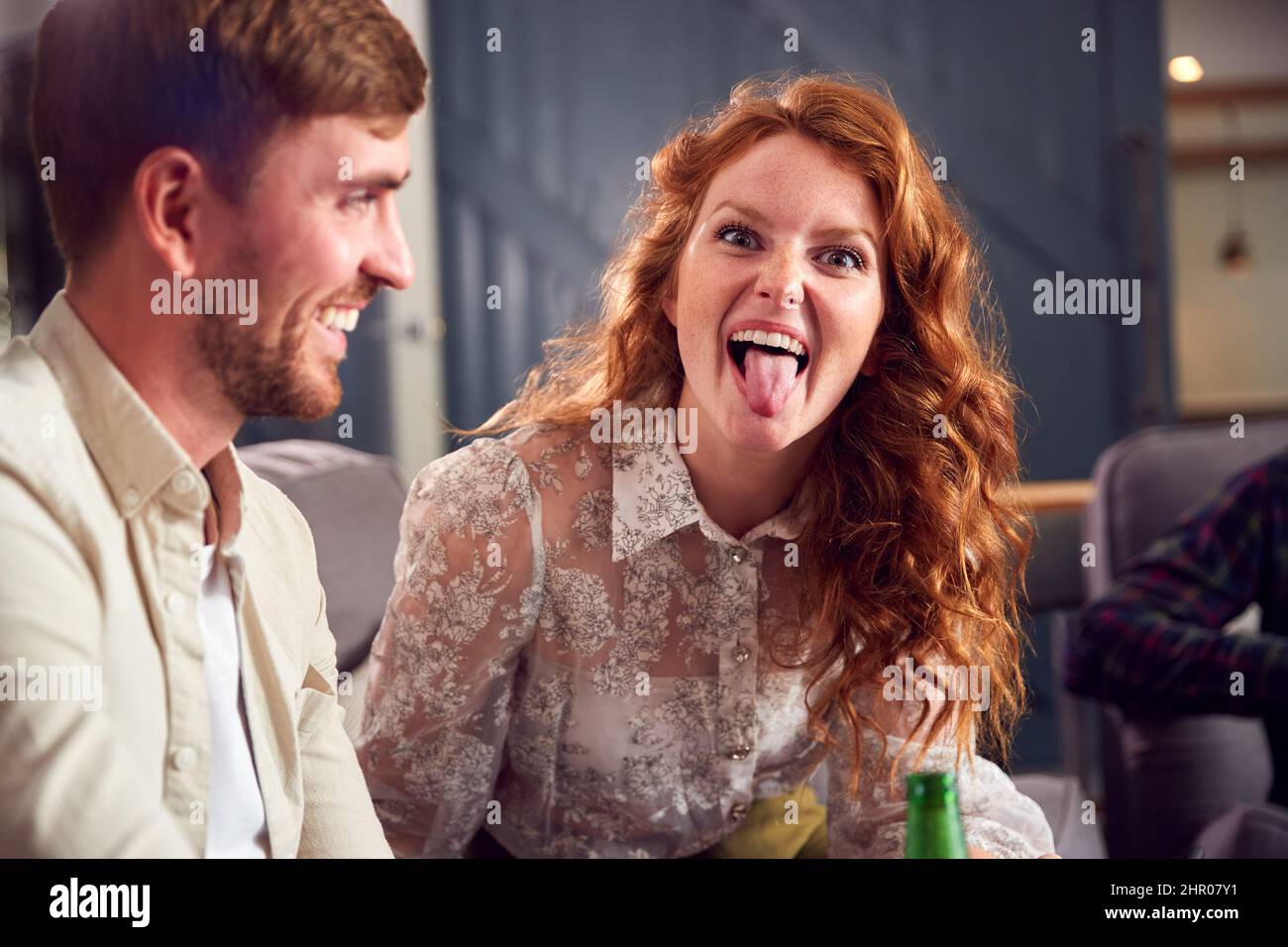 Donna in giovane coppia fare faccia seduta sul divano parlare insieme mentre gli amici si incontrano a casa Foto Stock