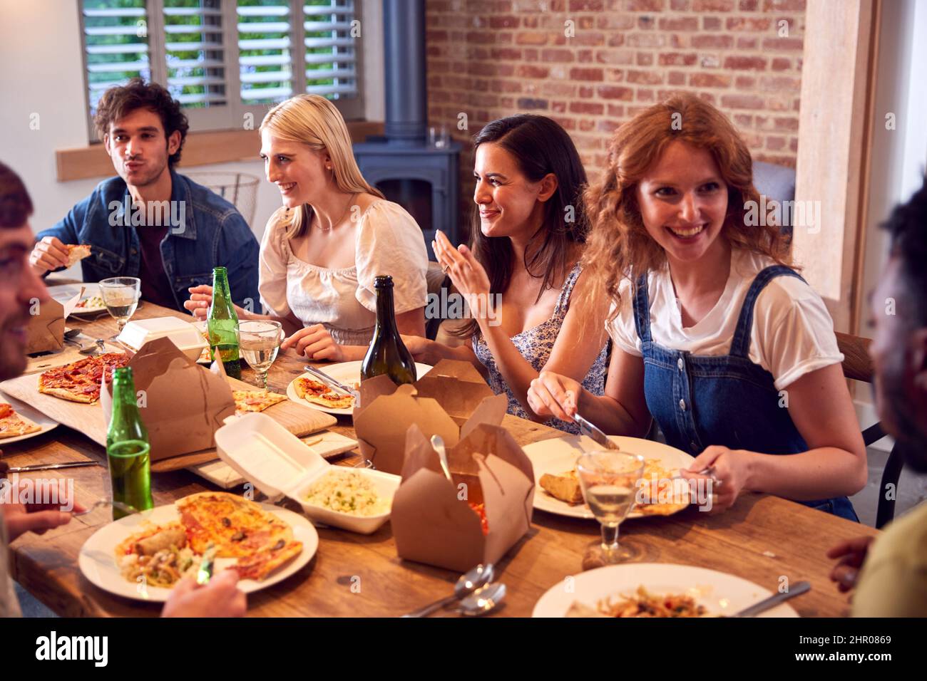 Gruppo multiculturale di amici che si godono insieme birra e pizza Party a casa Foto Stock