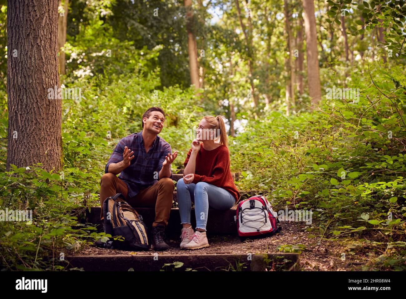 Coppia in campagna Escursionismo lungo Sentiero attraverso la foresta sedersi e fare una pausa insieme Foto Stock