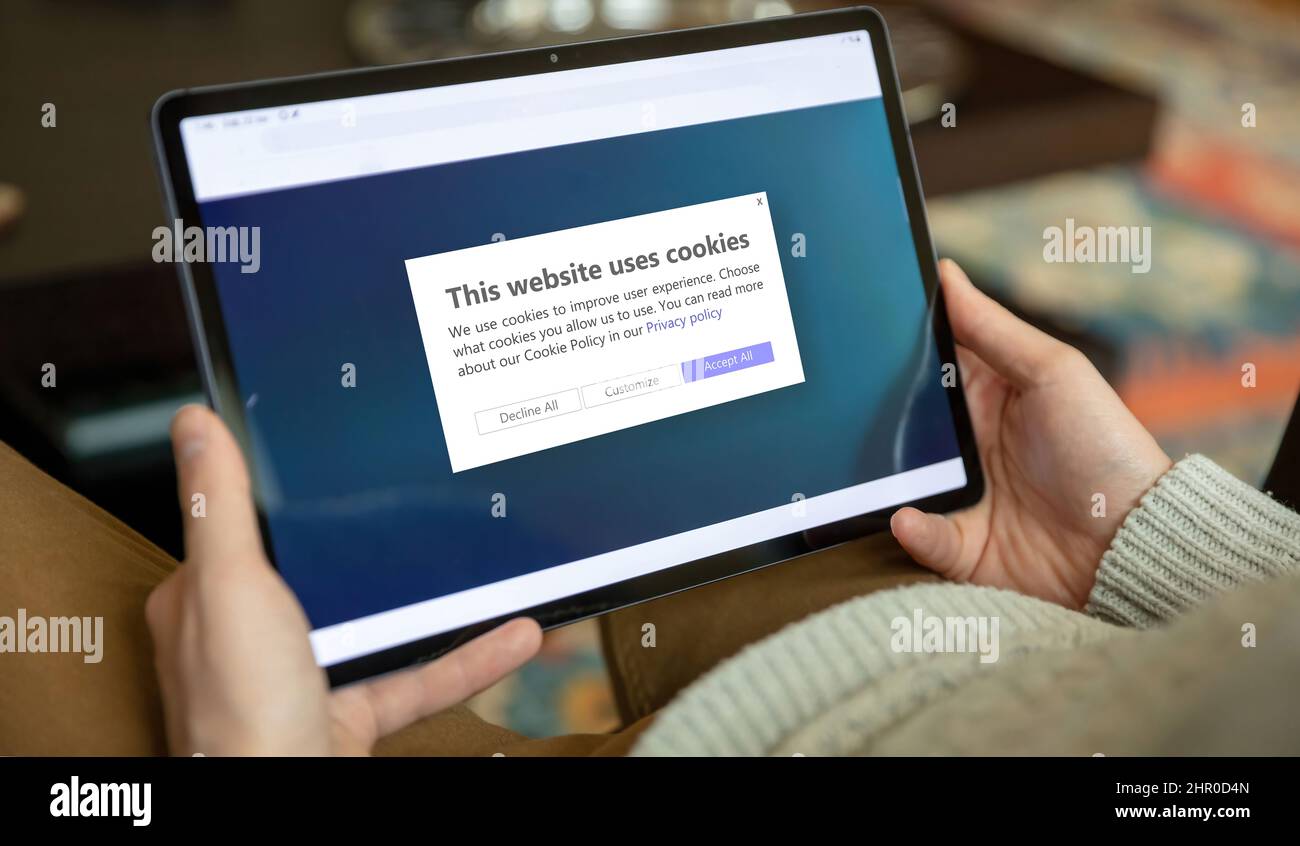 Messaggio informativo sulla politica dei cookie, gestione dei cookie. Uomo che detiene un tablet, sito web chiedere l'autorizzazione dell'utente per l'uso dei dati personali. Foto Stock