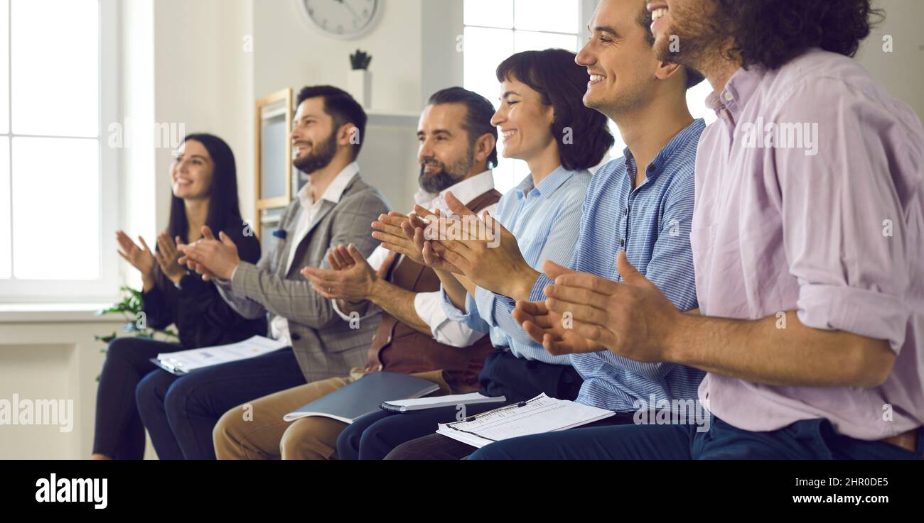 Un pubblico felice applaudendo un oratore in una conferenza di lavoro o in una riunione aziendale Foto Stock