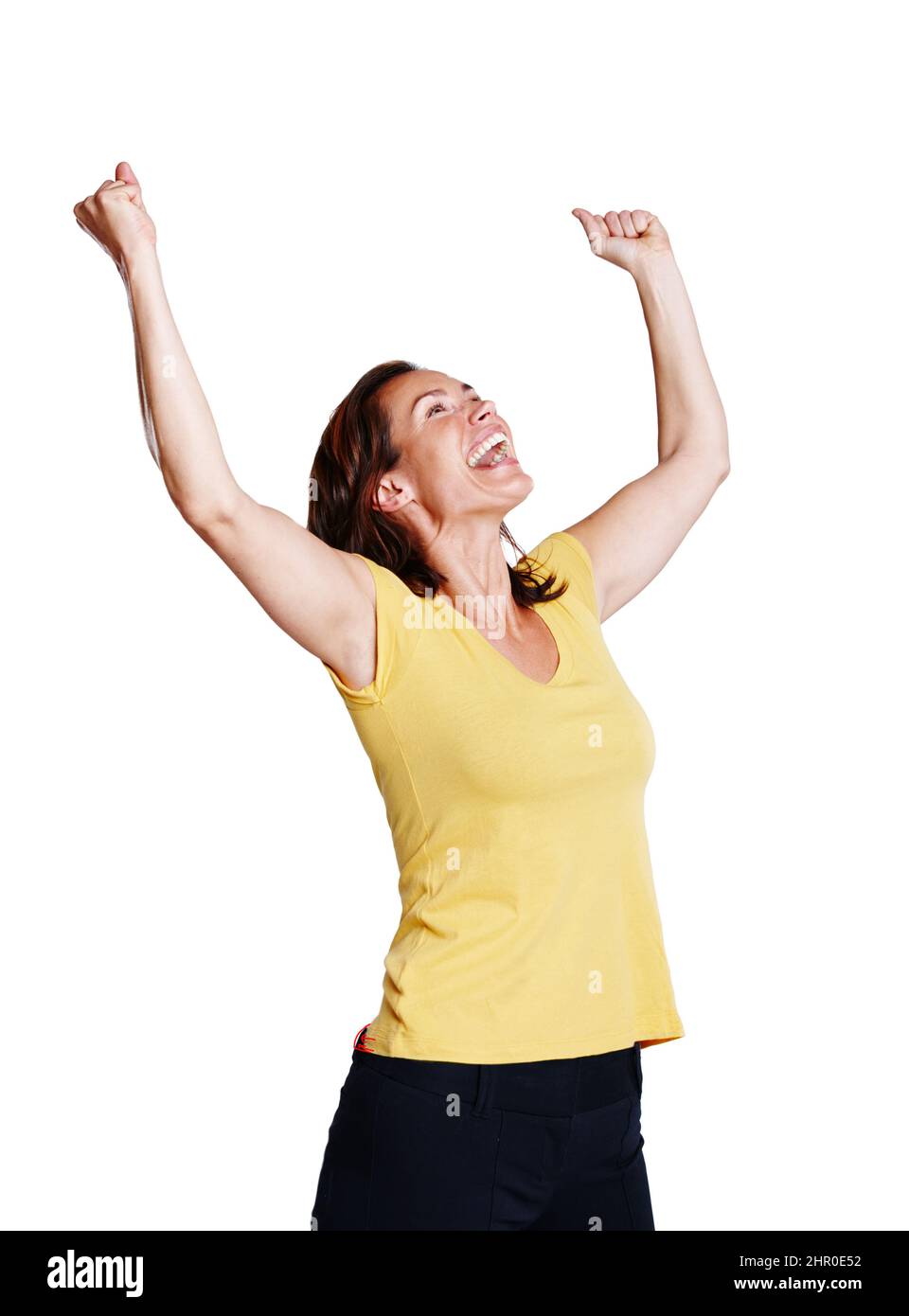 Celebrando il suo successo. Studio girato di una donna che festeggia con le braccia tese nell'aria isolata su bianco. Foto Stock