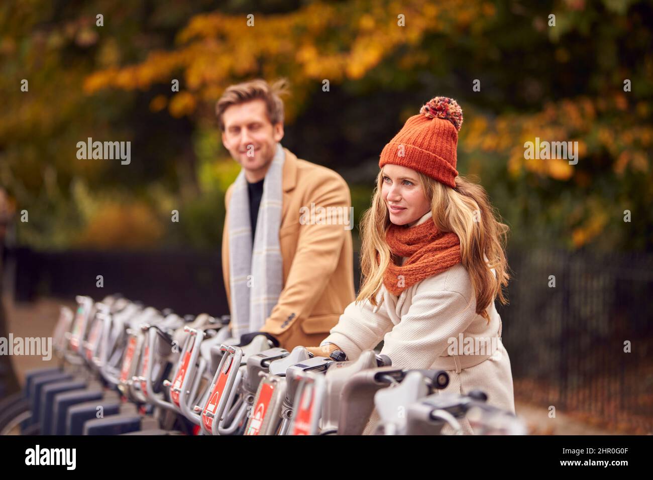 Coppia Noleggio biciclette come forma verde di trasporto per girare la città in autunno o in autunno Foto Stock