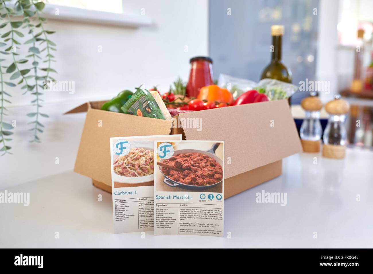 Schede di ricetta dalla scatola dal corredo di ricette dell'alimento di pasto in linea con gli ingredienti freschi consegnati a casa Foto Stock