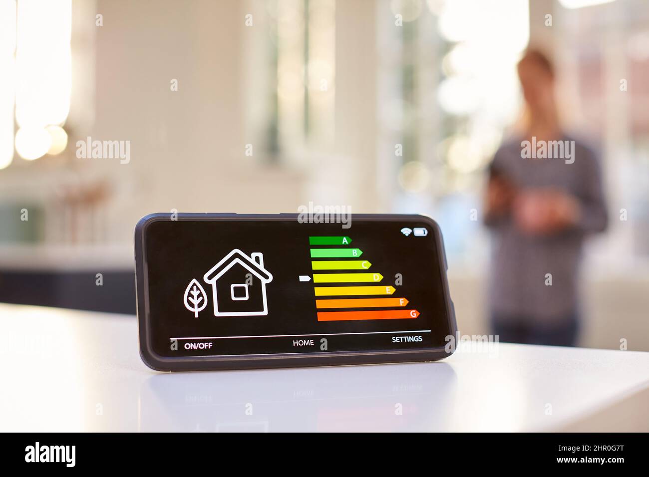 Contatore di energia intelligente in cucina misurazione dell'efficienza energetica con la figura in background Foto Stock