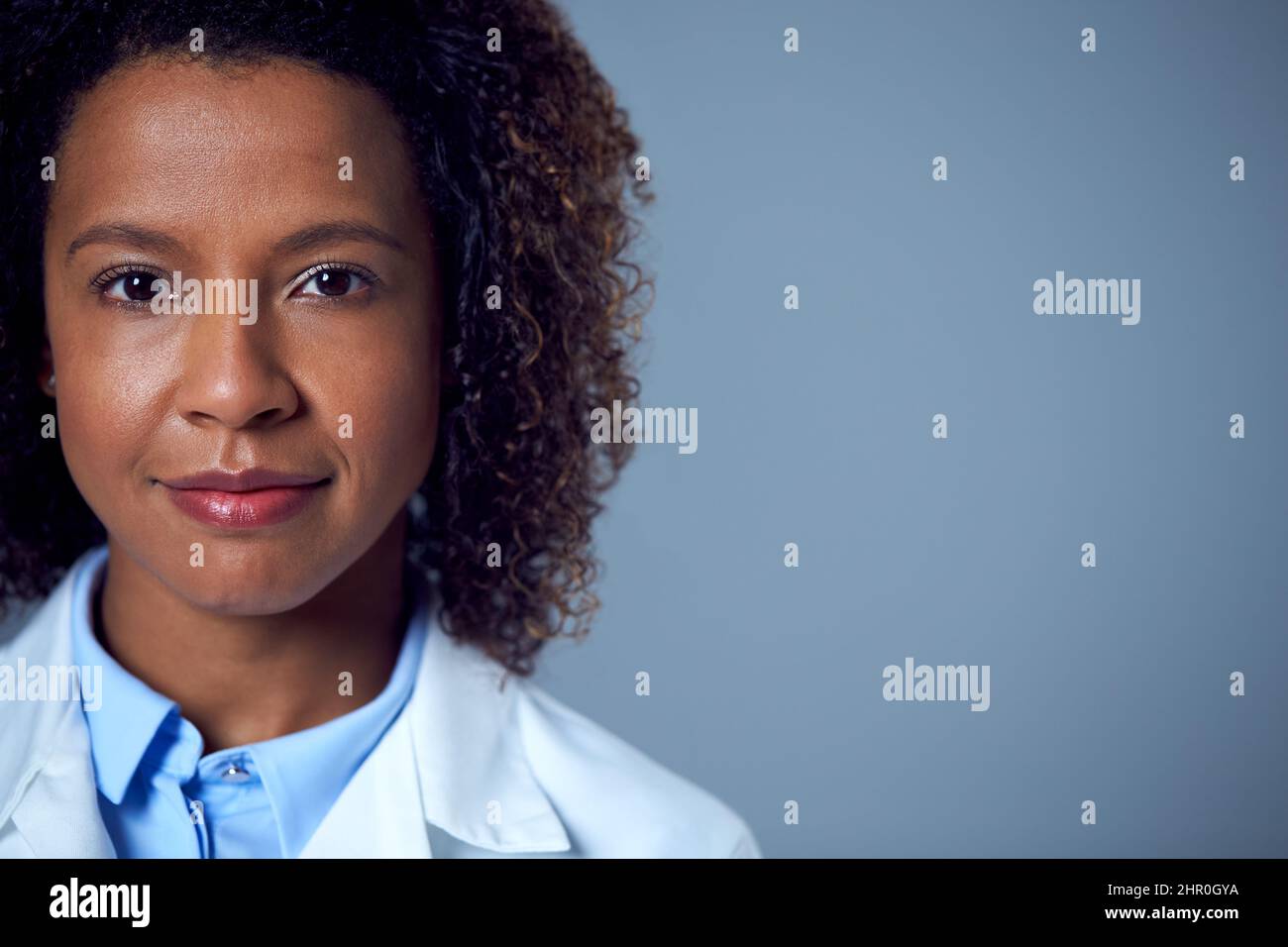 Studio Ritratto di Smiling Female Doctor o Lab Worker in White Coat Foto Stock