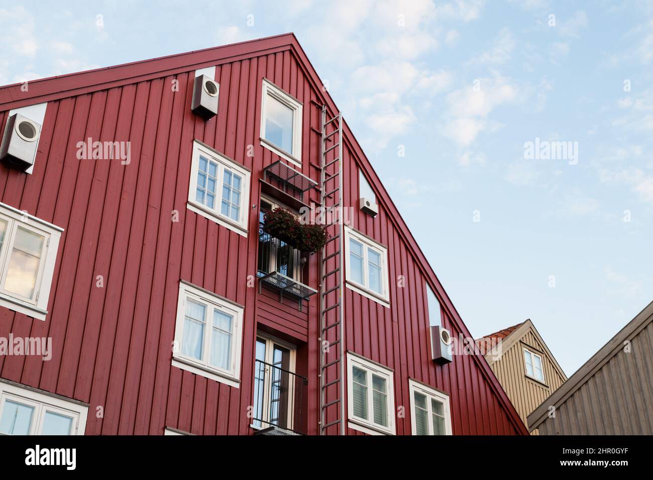 Muro di casa in legno rosso con finestre e scala, tradizionale architettura norvegese Foto Stock