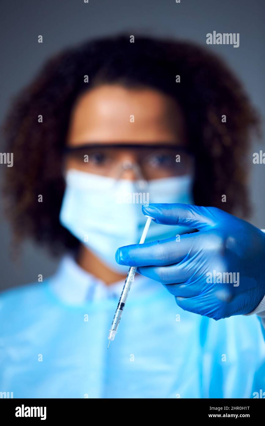 Female Lab Research Worker che indossa la siringa di fissaggio PPE per la vaccinazione Foto Stock