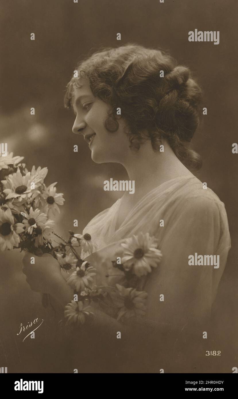 Foto retrò dipinta di una giovane donna in profilo con un bouquet di fiori. Foto Stock