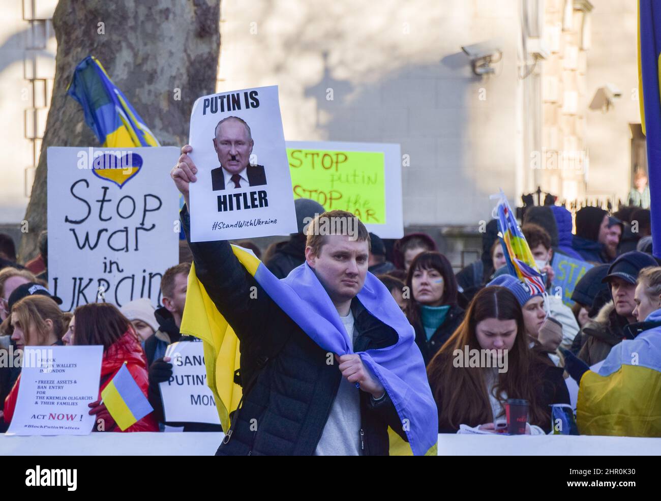 Londra, Regno Unito. 24th febbraio 2022. Un manifestante ha un cartello che paragona Putin a Hitler. I manifestanti si sono riuniti fuori Downing Street per protestare contro l'invasione russa dell'Ucraina e hanno chiesto al governo britannico di aiutare l'Ucraina e di imporre ulteriori sanzioni alla Russia. Credit: Vuk Valcic/Alamy Live News Foto Stock