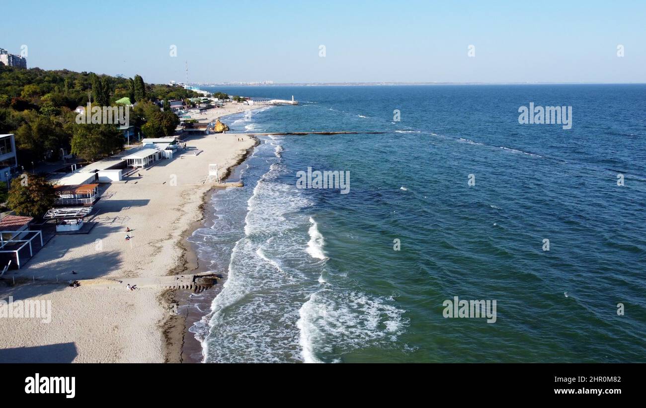 La gente cammina e si rilassa sulla spiaggia durante la giornata di sole. Volo aereo con vista sui droni Foto Stock