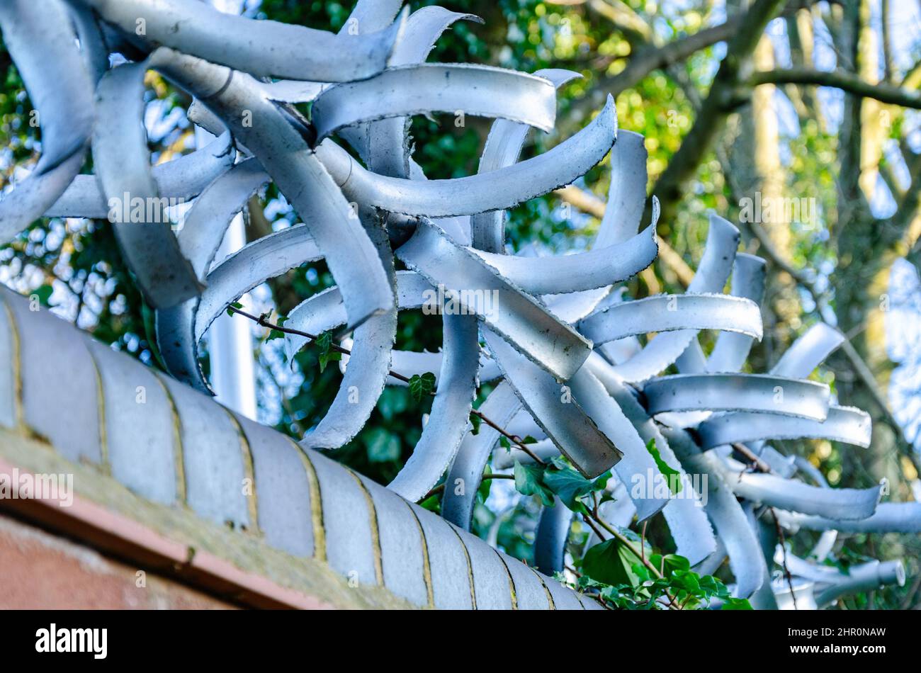 Un deterrente di arrampicata lungo la parte superiore di una parete di mattoni è una misura di sicurezza per aiutare a prevenire gli intrusi. Foto Stock