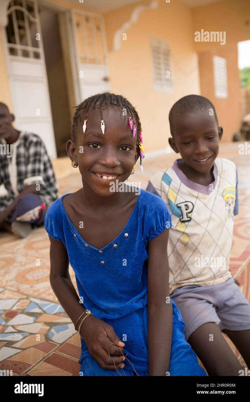 Penda Dioum (10, l) e suo fratello Assane Dioum (6, r) siedono fuori della loro casa di recente costruzione sull'isola di Morphil nel dipartimento di Podor, Senegal. Thei Foto Stock
