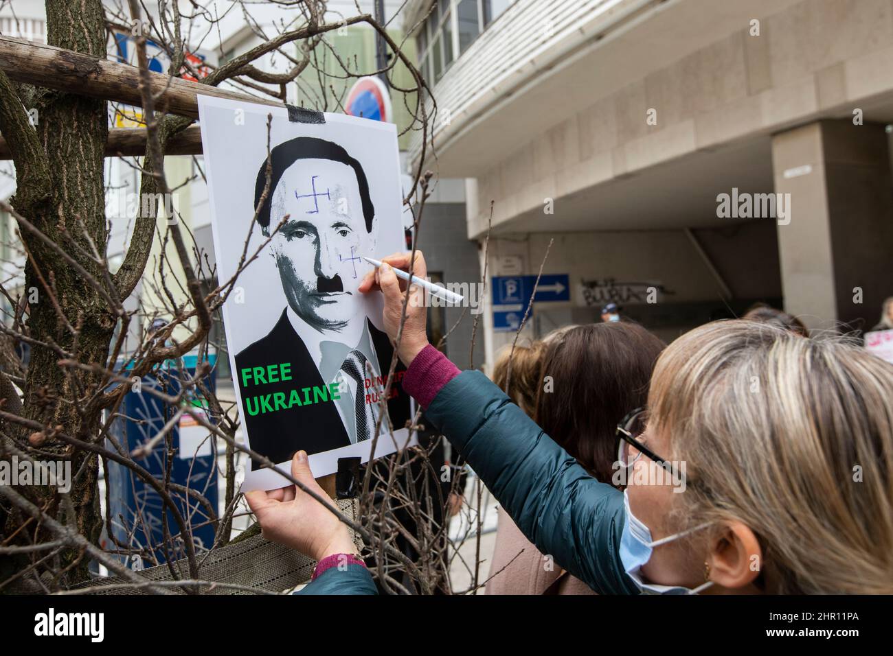 Lisbona, Portogallo. 24th Feb 2022. Un manifestante ha visto disegnare un simbolo nazista su una targhetta del volto di Vladimir Putin durante la dimostrazioneHundred dei manifestanti, ha protestato contro l'invasione dell'Ucraina di fronte all'ambasciata russa in Portogallo. Credit: SOPA Images Limited/Alamy Live News Foto Stock