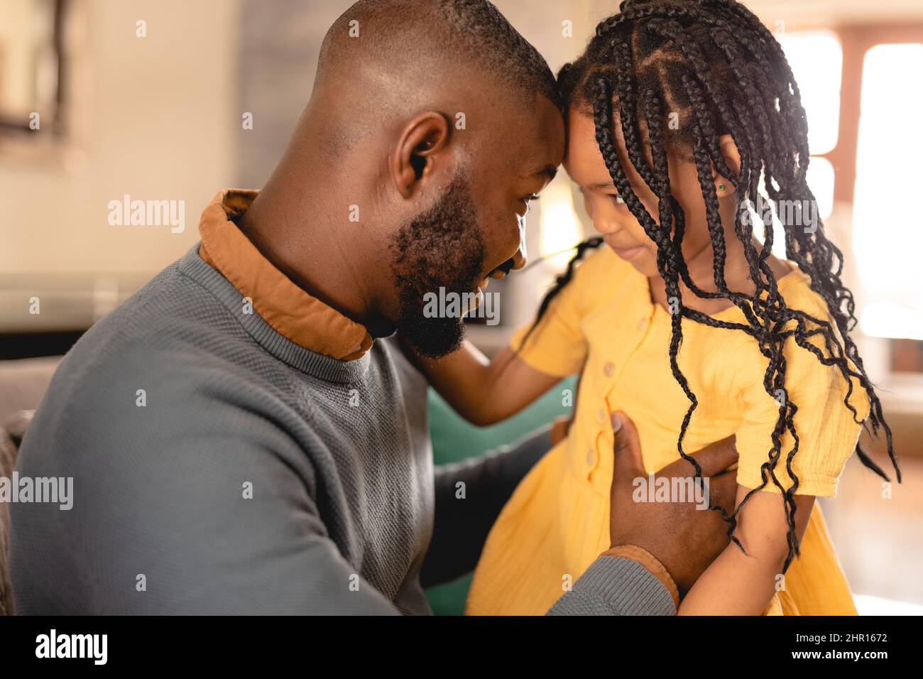 Amorevole padre e figlia afroamericana che tocca le fronte all'interno della casa Foto Stock