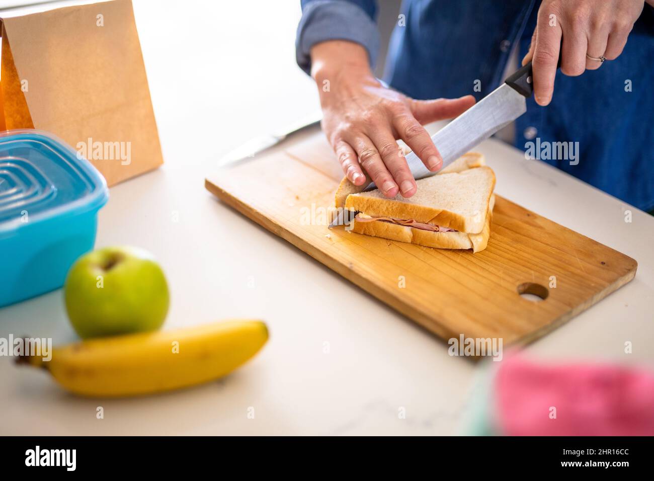 Sezione media di donna caucasica matura taglio sandwich per pranzo scatola Foto Stock