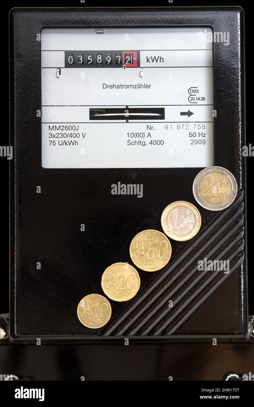 Contatore elettrico con monete in euro ascendenti da 10 centesimi a 2 euro. I prezzi del gas, dell'elettricità e della benzina stanno aumentando rapidamente. Foto Stock