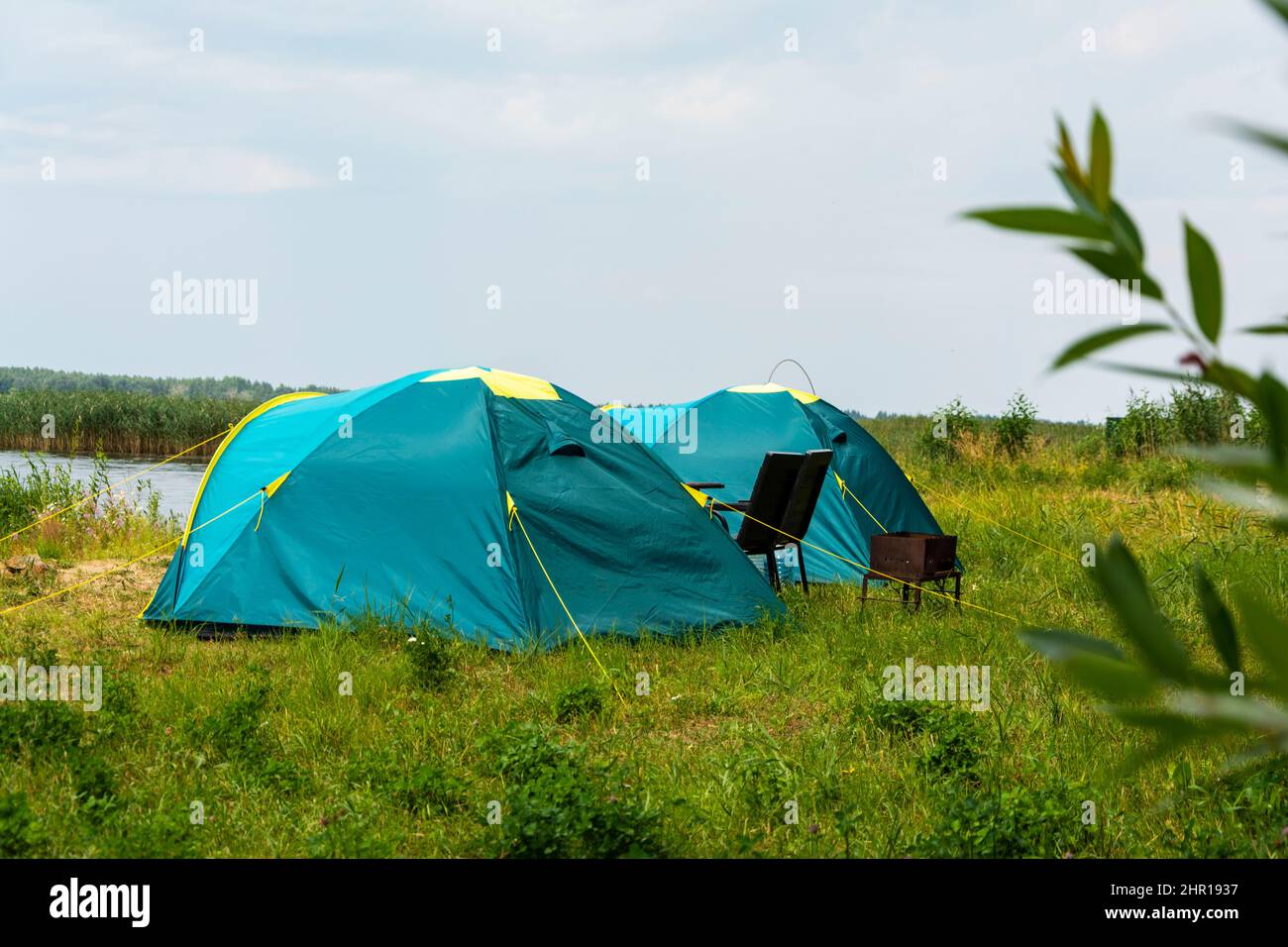 Tende turistiche per campeggio sulla riva del lago, storia di viaggio, pesca, turismo, attività ricreative. Paesaggio naturale. Per un design di stile di vita. servizi ricreativi all'aperto Foto Stock