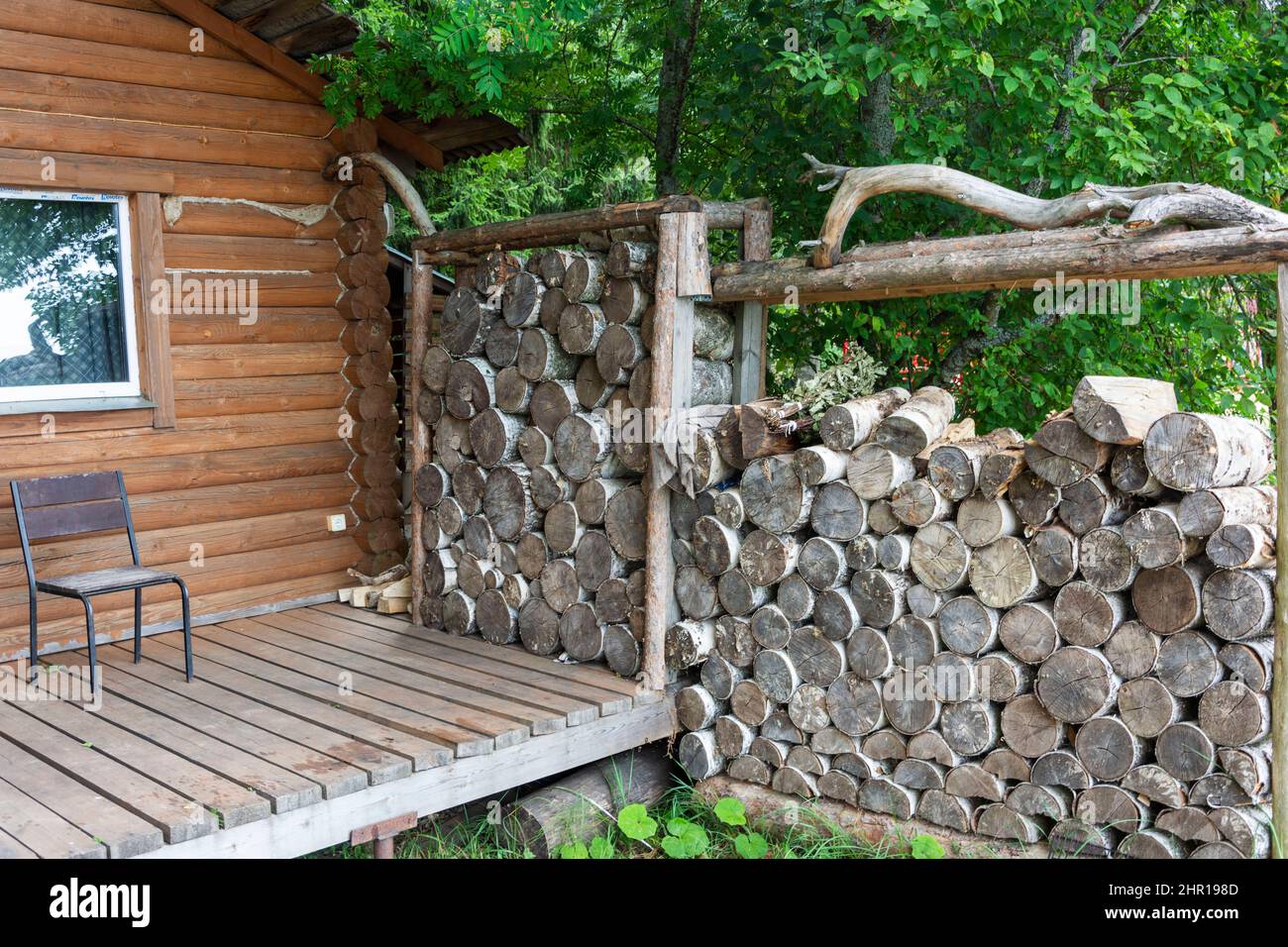 Legna da ardere per la stufa sauna, saune sono impilati accanto al bagno in legno rurale. Per un design di stile di vita. C'è una fila di legna da ardere contro il muro. RUR Foto Stock