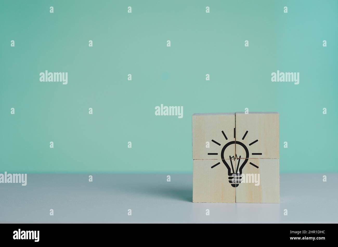 Cubo di legno con icona lampadina. Idee e idee di creatività sullo sfondo. Foto Stock