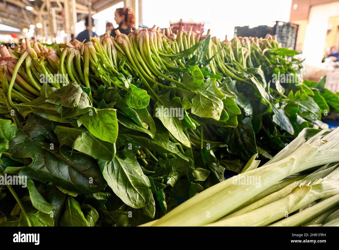 Spinaci verdi freschi in vendita al mercato vegetale, primo piano. Scatole piene di spinaci in negozio. Spinaci alla stalla del fruttivendolo. Impianto beta. Vegetale. Foto Stock