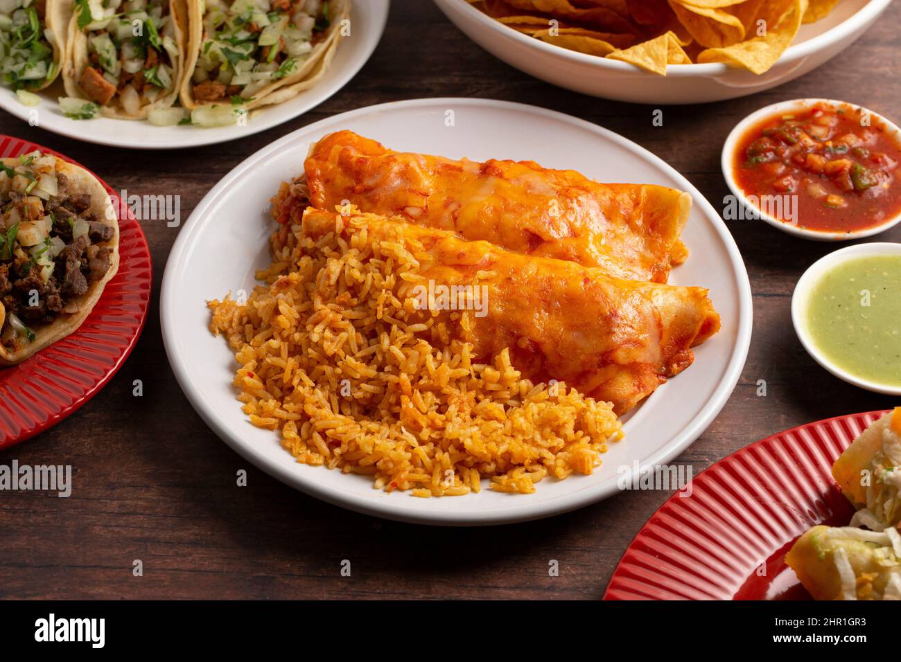 Un paio di Enchiladas con salsa rossa e riso stagionato Foto Stock