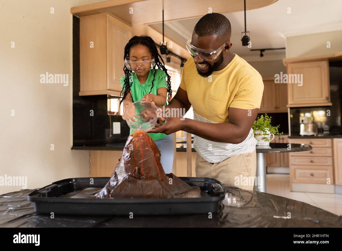 Sorridendo padre e figlia afroamericana sperimentando in cucina a casa Foto Stock
