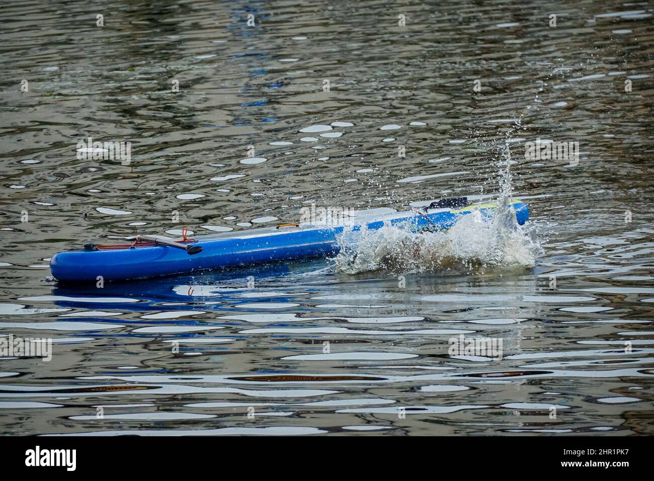 spruzzi da un uomo che tuffa nell'acqua da un sup Foto Stock