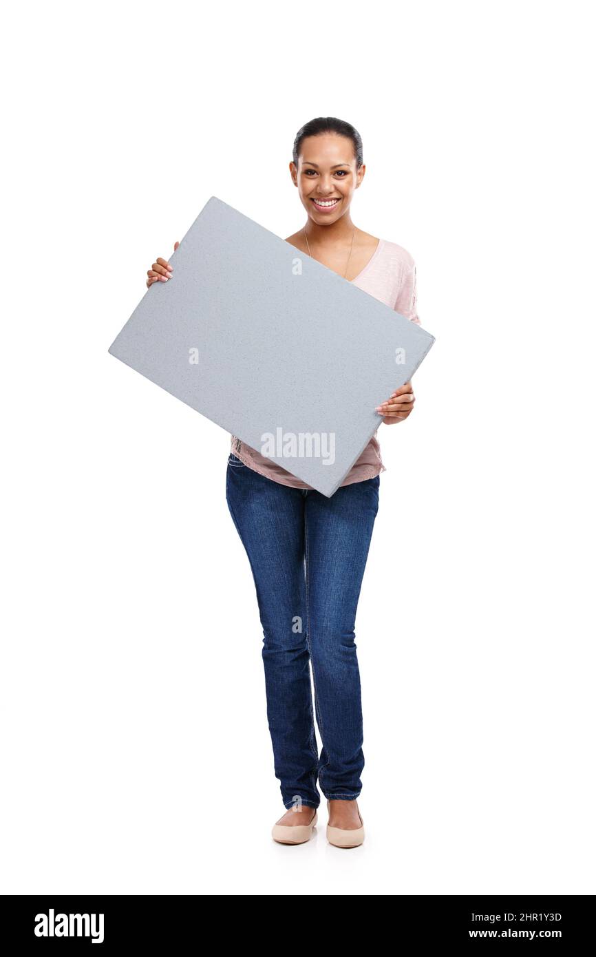 Prova questo spazio. Ritratto a tutta lunghezza di una giovane donna attraente in uno studio che tiene una tavola isolata su bianco. Foto Stock
