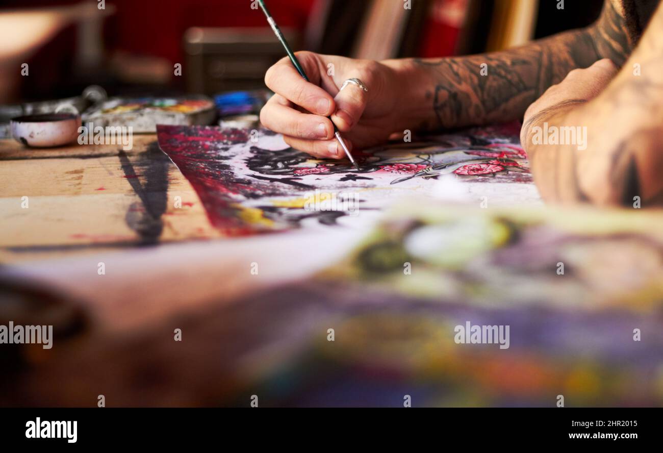 La chiave è nei dettagli. Primo piano di un artista tatuaggio che utilizza il colore e un pennello che lavora alla sua ultima opera d'arte. Foto Stock