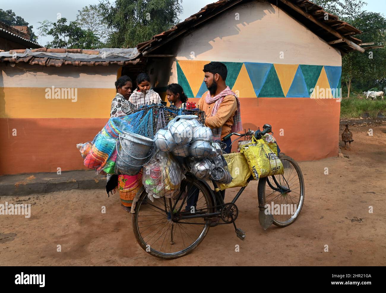 Il falhker vende giornalmente le cose con il suo ciclo a porta nella remota area del villaggio di Purulia, Bengala Occidentale in India. Foto Stock