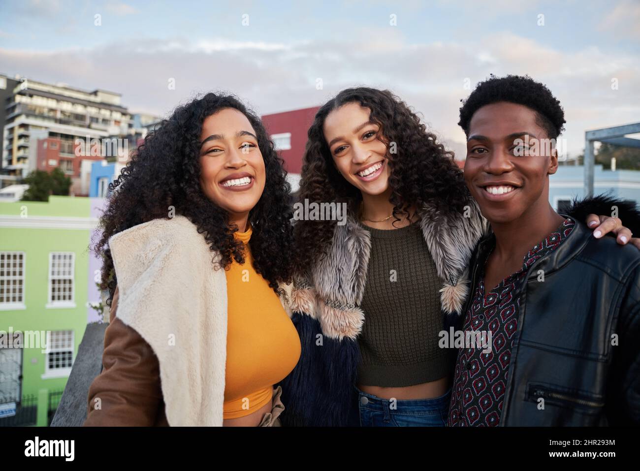 Ritratto di diversi gruppi di giovani adulti multiculturali in piedi, sorridendo a macchina fotografica su una terrazza panoramica della città Foto Stock