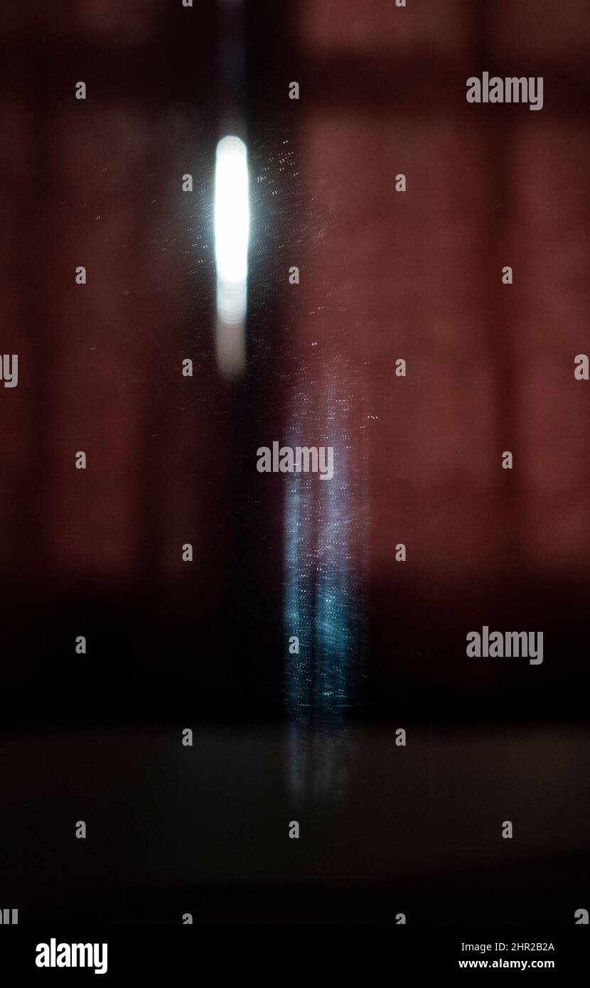 La prima luce del giorno si riflette sulla parete di una camera da letto e in uno specchio creando curiose forme astratte luminose. Foto Stock