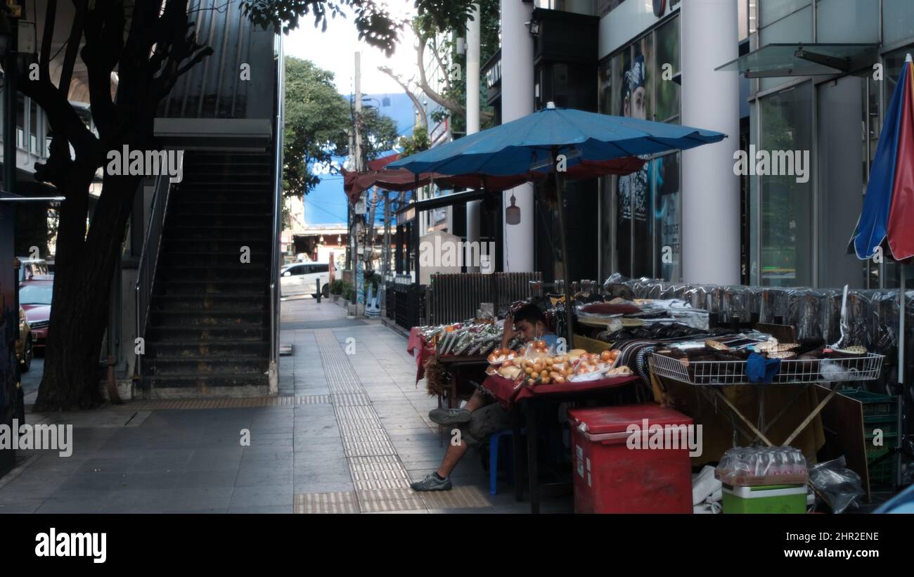 Sidewalk Vender ingresso skytrain Sukhumvit Road aka Highway 3 Asoke Bangkok Thailandia Foto Stock