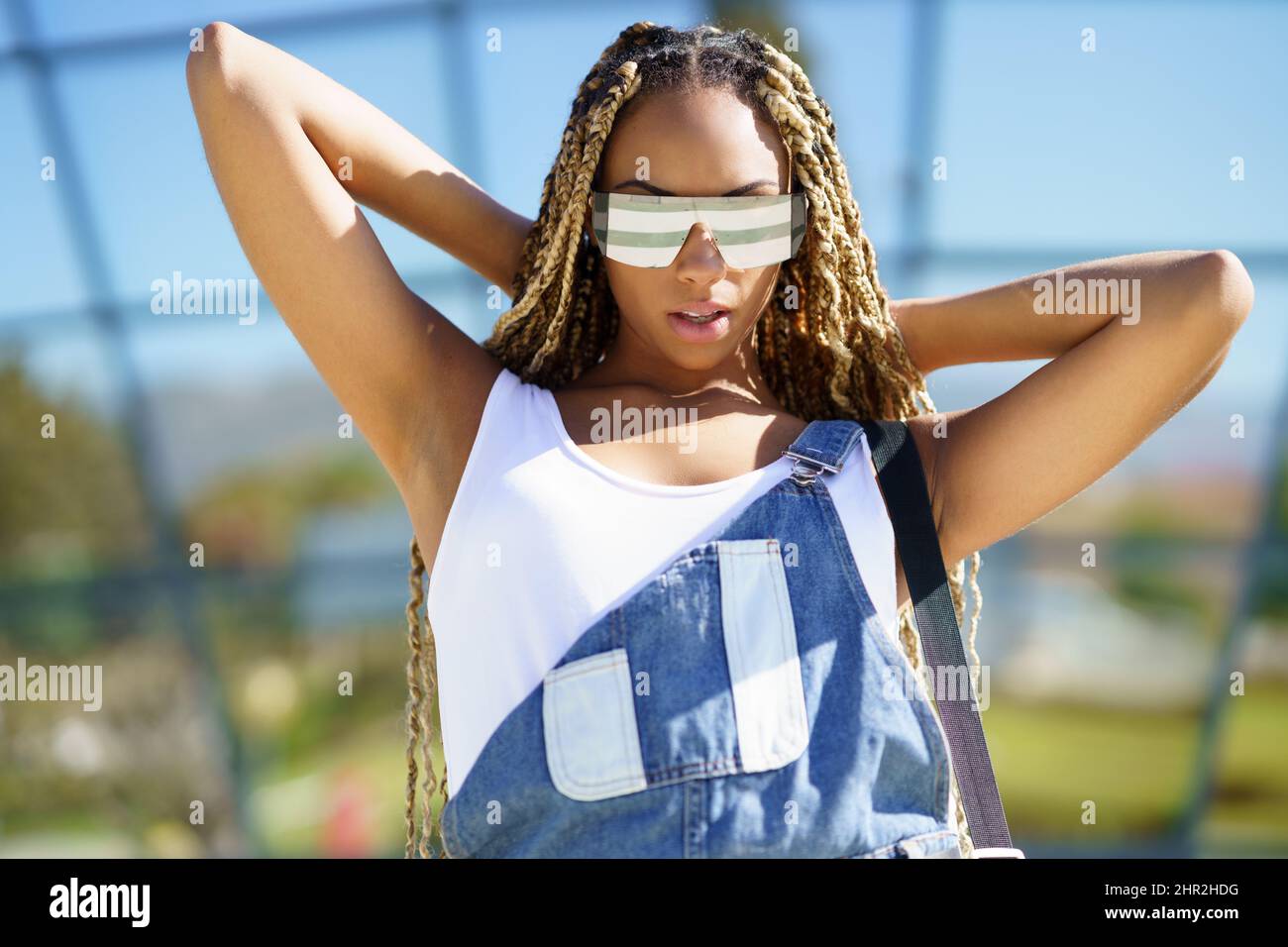 Ragazza nera vestita casual, guardando la macchina fotografica con occhiali  da sole moderni Foto stock - Alamy